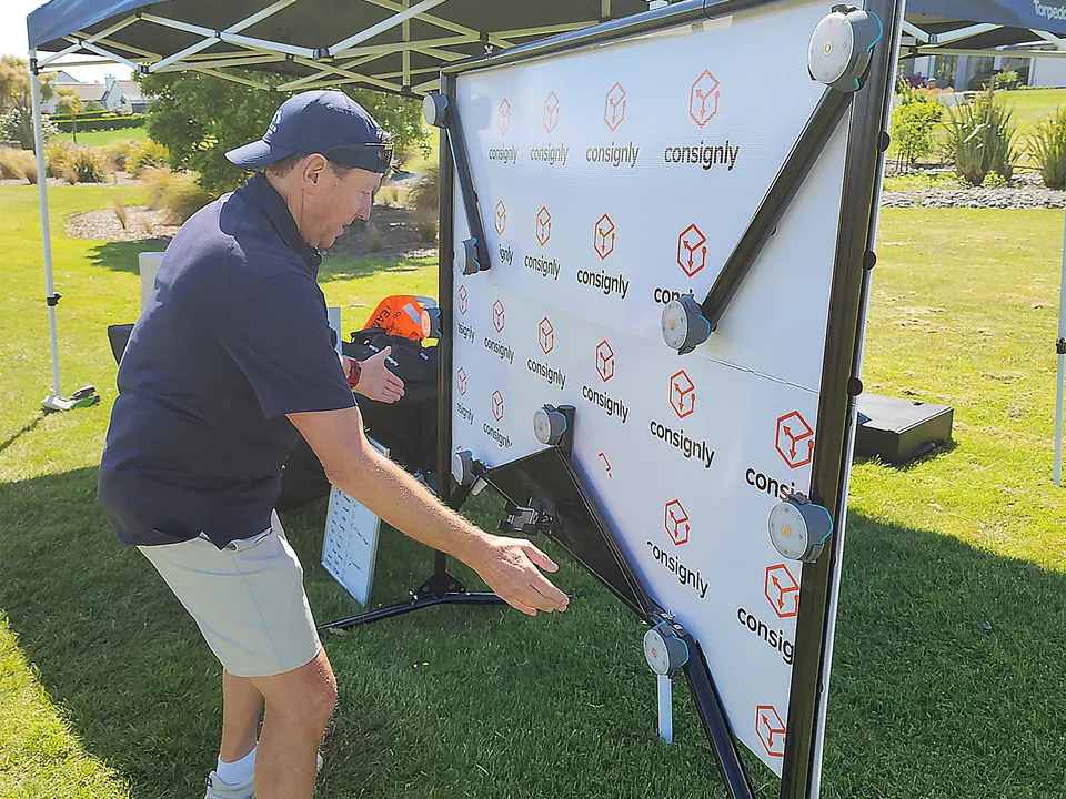 Man playing the reaction timer wall challenge at an outdoor event